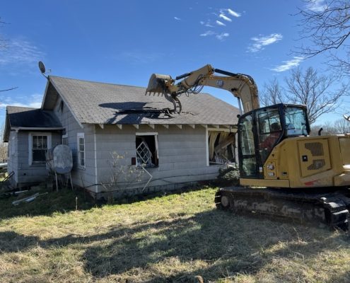 A machine performing demolition on a house.