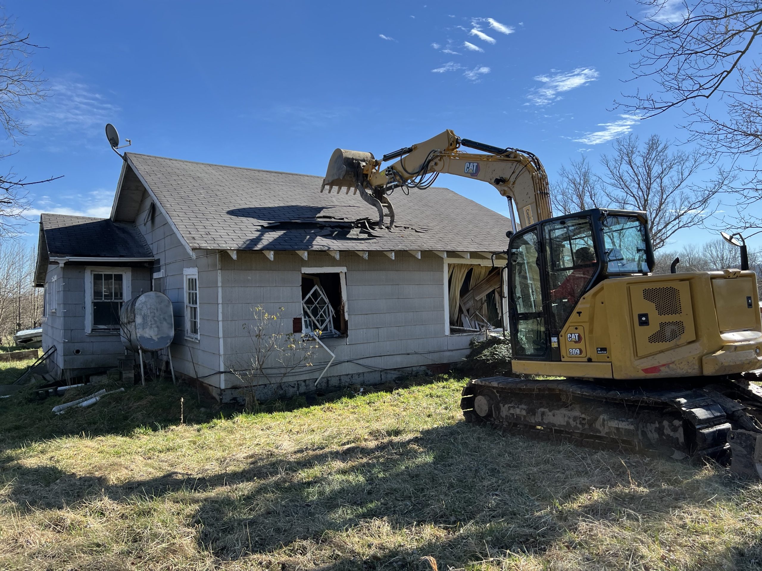 A machine performing demolition on a house.