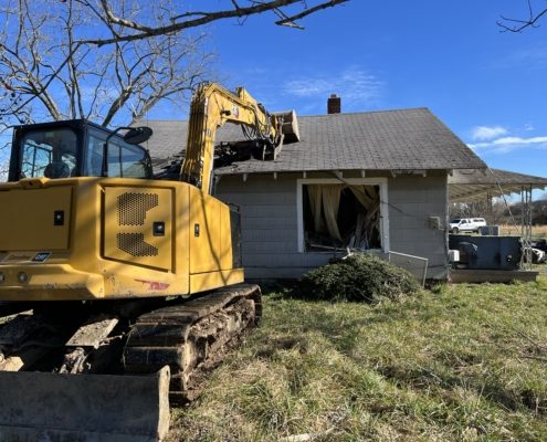 A machine performing demolition on a house.