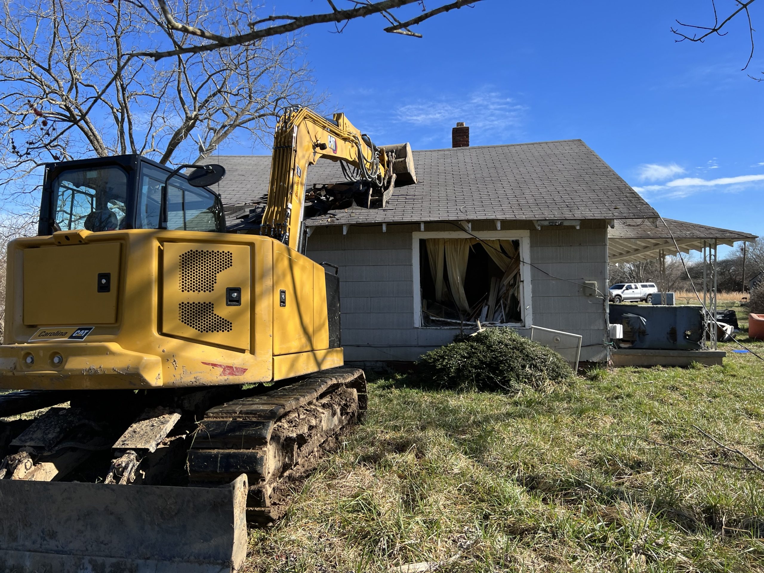 A machine performing demolition on a house.